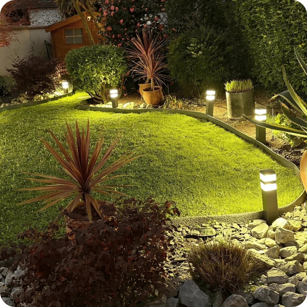 Outdoor garden lighting: LED bollard lights installed along a lawn, lit at night