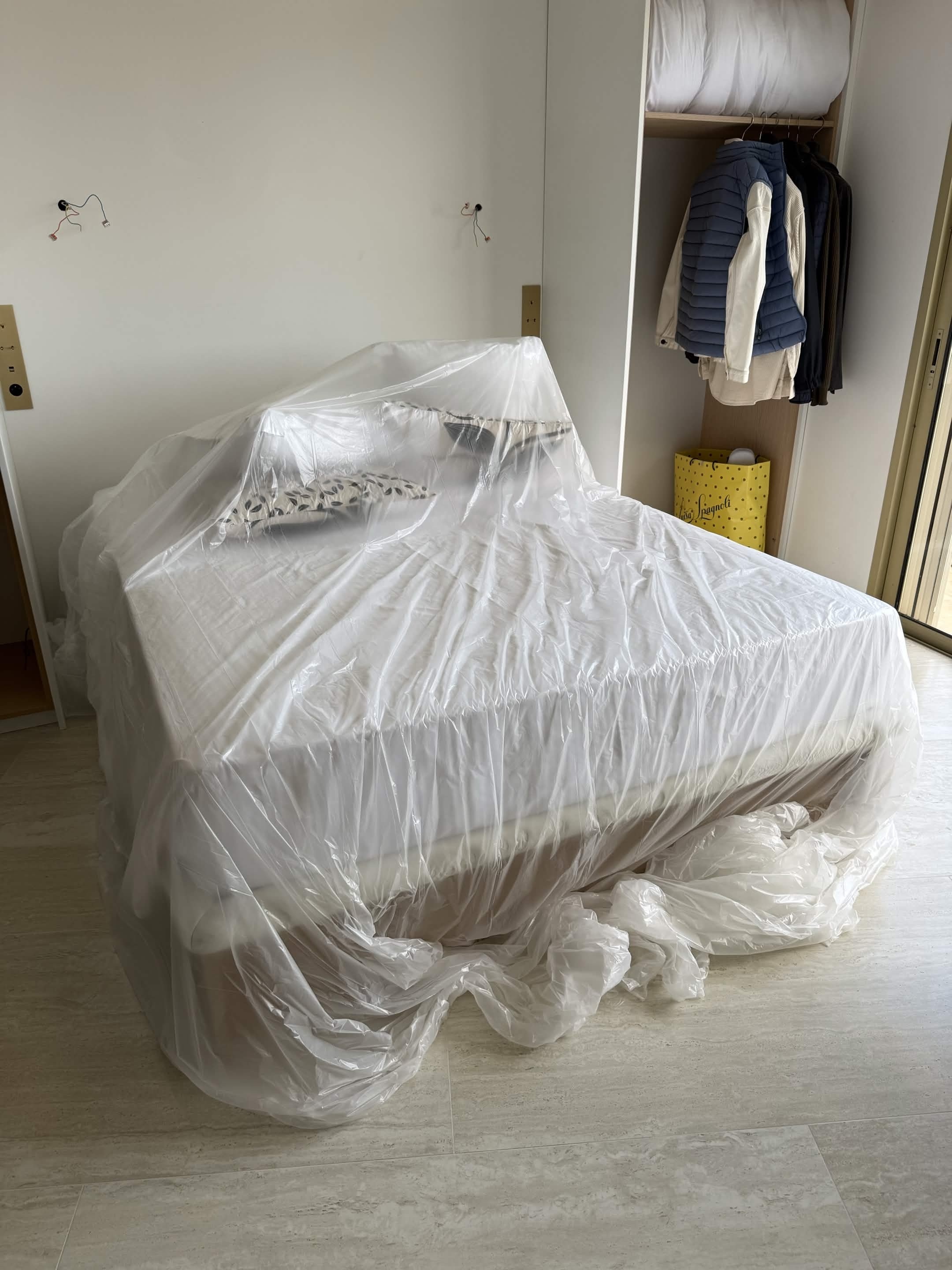 Protection du mobilier du client avec une bâche plastique avant installation du plafonnier