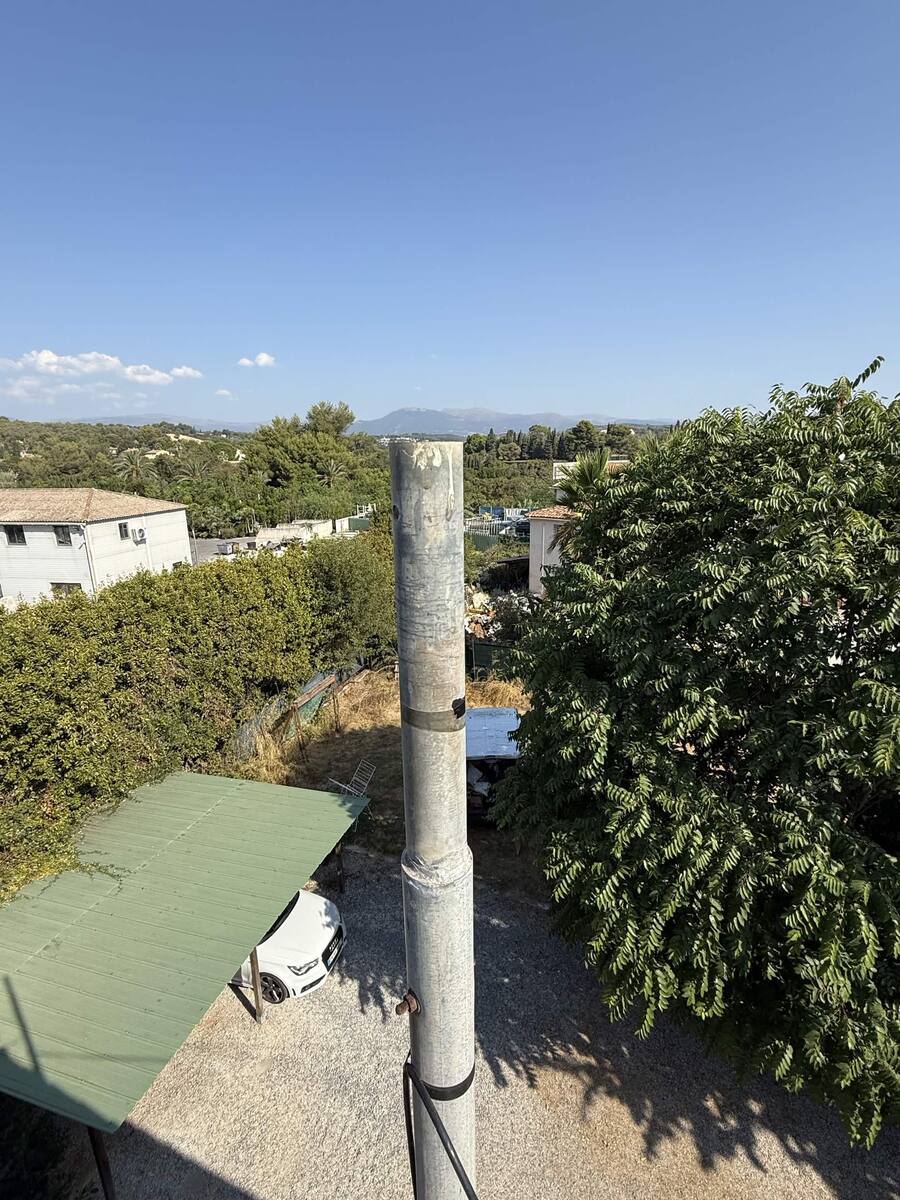 Starlink-Installationsmast in der Höhe befestigt, Blick vom Dach mit der Landschaft der Alpes-Maritimes im Hintergrund